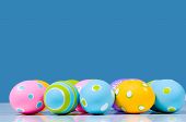  Brightly Colored Easter Eggs On Blue Background With Reflection