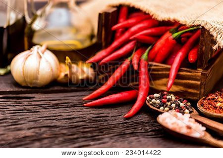 Wooden Spoons With Dried Ginger, Peppercorn, Salt, Garlic, Oil, Balsamic Vinegar, And Red Chili Pepp