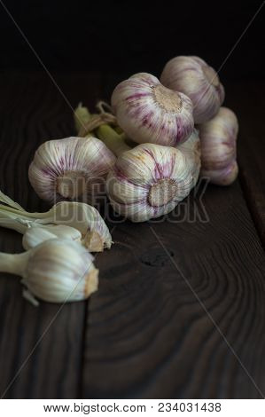 Garlic Heads On A Dark Wooden Table