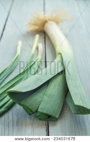 Green Onions And Leek On A White Wooden Table