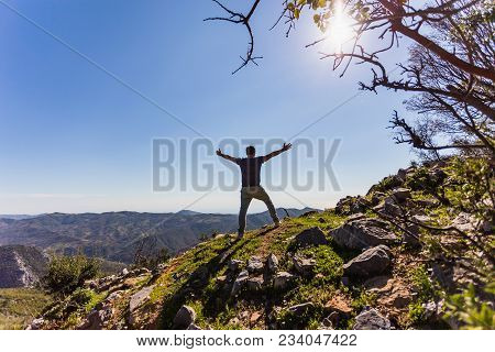 Traveller Man In Summer Outfit With Arms Spread Overlooking Mountain View.