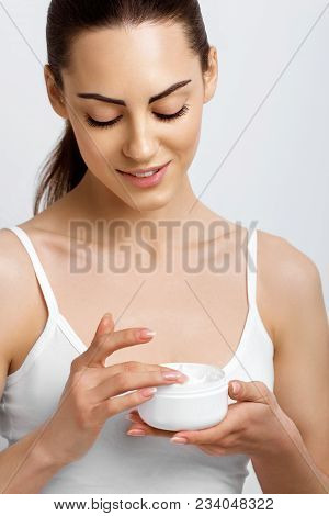 Face Skincare. Woman With Healthy Smooth Facial Clean Skin Holding Bottle Cream.beauty Face Care.fac