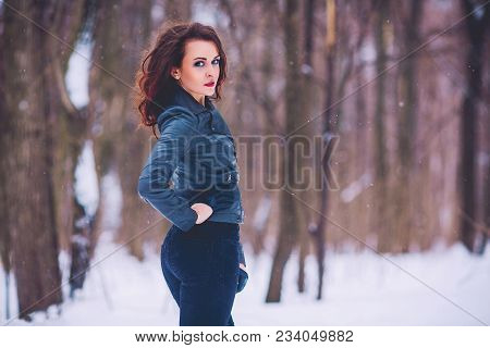 Girl Brunette Against The Background Of The Winter Forest