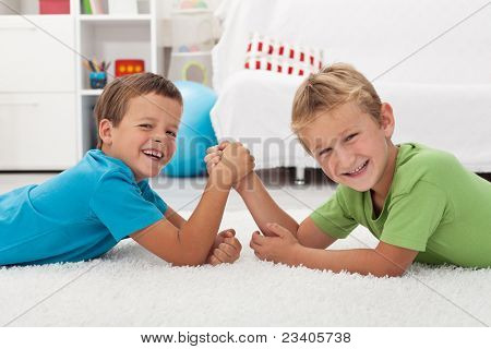 Happy kids leende og arm wrestling - fokus på den venstre dreng