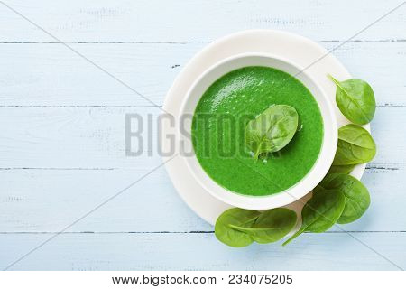 Green Spinach Soup In Bowl On Rustic Table Top View.