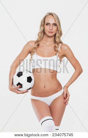 Sexy Beautiful Woman With Long Shapely Legs In White Lingerie, Socks And Boots Posing With A Soccer 