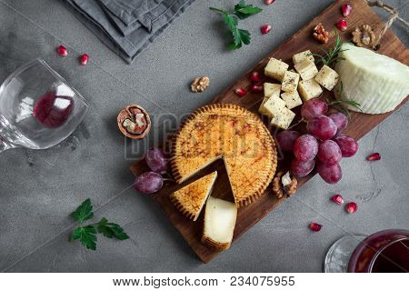 Cheese Platter With Assorted Cheeses, Grapes, Nuts Over Black Background, Copy Space. Italian Cheese