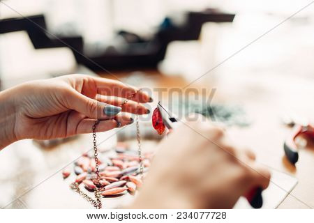 Female person holds pliers, bijouterie making
