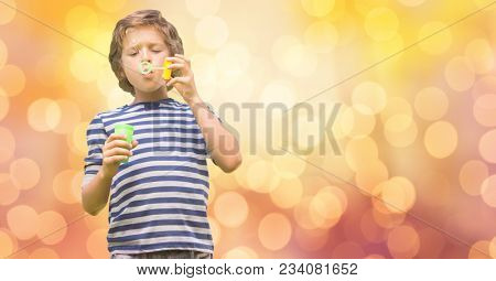 Boy playing with bubble wand over bokeh