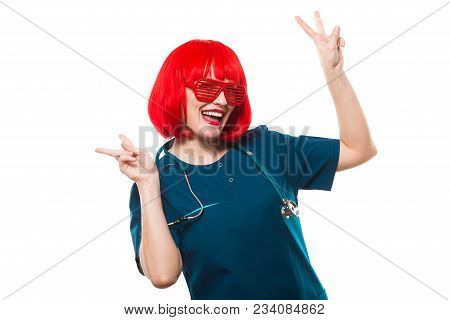Beautiful Happy Cheerful Woman Doctor Looking In Camera Funny Showing Sign With Red Wig And Sunglass