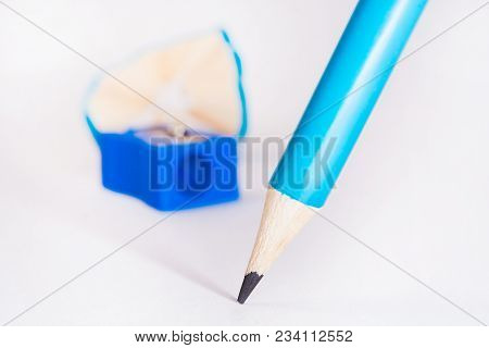 Blue Pencil With Blue Pencil Sharpener And Sharpening Shavings On White Background. Stationery. Offi