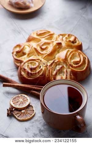 Festive Composition Of Homemade Rose Bread With Raisins, Cup Of Tea, Dried Citrus, Anise And Cinnamo