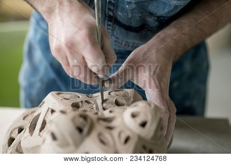 Ceramist Dressed in an Apron Sculpting Statue from Raw Clay in the Bright Ceramic Workshop.