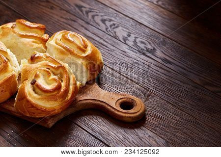 Homemade Rose Buns With Raisins On Wooden Cutting Board Over Rustic Vintage Background, Close-up, Sh