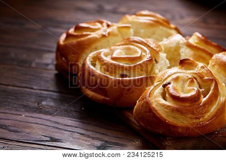 Homemade Rose Buns With Raisins On Wooden Cutting Board Over Rustic Vintage Background, Close-up, Sh