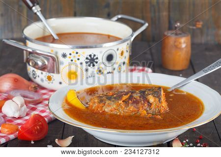 Fish Head Soup With Vegetables In The Pot. Wooden Table Filled With Ingredients, Fresh Vegetables, R