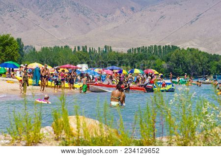 People Enjoy Sun And Hot Weather Near Cholpon-ata Beach , Issyk-kul Lake, Kyrgyzstan 30.07.2017