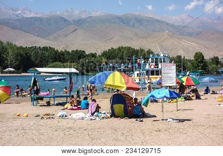 People Enjoy Sunny Weather Near Cholpon-ata Beach , Issyk-kul Lake, Kyrgyzstan 30.07.2017