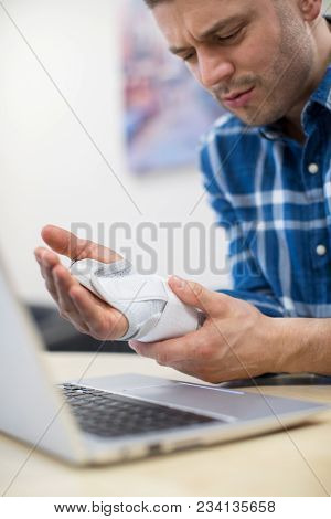 Businessman Using Laptop Suffering From Repetitive Strain Injury (rsi)