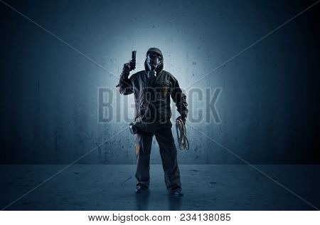 Bad agent in a dark room with arms on his hand and gas mask