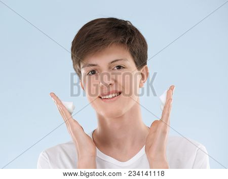 Teenage Boy With Problem Skin Applying Anti Acne Cream On Light Background
