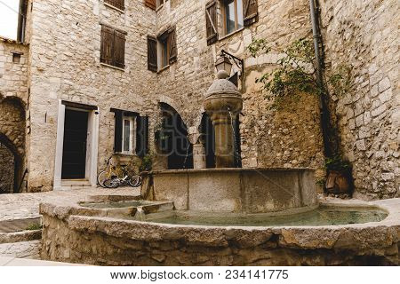 Atrium Of Ancient Buildings At Old Town With Beautiful Fountain, Peille, France