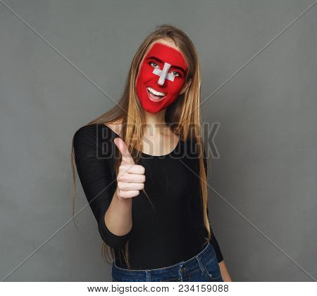 Portrait Of A Woman With The Flag Of Switzerland Painted On Her Face. Football Or Soccer Team Fan, S