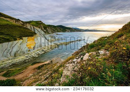 A View To The Coastine Of Basque Country Near Zumaia Fluch With Vibrant Rocks And Dramatic Sunset Sk