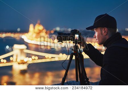 Photographer With Tripod. Young Man Taking Photo With His Camera In The Night City. Budapest, Hungar