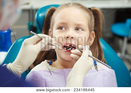 Child Lies In Comfortable Dentis Chair And Goes Through Procedure Without Fear While Female Doctor I