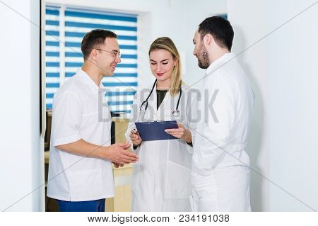 Group Of Doctors Discussing And Working Together.