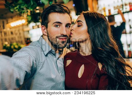 Another Selfie Of Couple. Girl Is Kissing Her Partner While He Is Taking A Picture. They Look Happy 