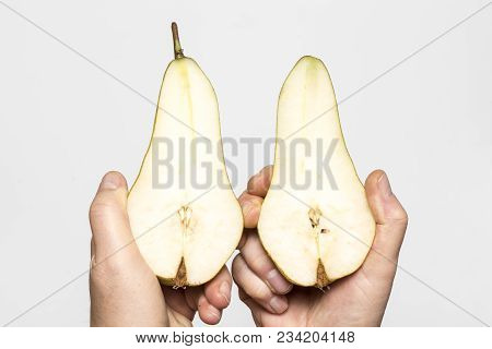 A Pear Fruit Cut In The Hands