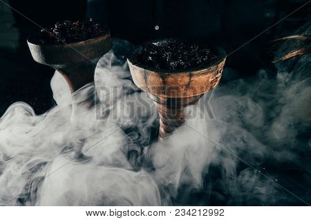 Shisha Bowl With Craft Tobacco And Red Coal With Hookah Blue And Red Smoke Background.