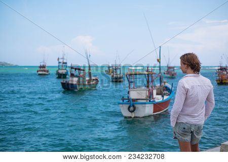 Caucasian Woman Standing On The Beach Of Midigama And Looking On Ocean And Traditional Colourful Loc