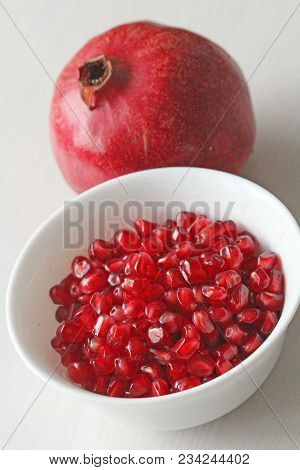 Grains Of Red Ripe Pomegranate Lie In A White Bowl. Big Ripe Red Granets Or Garnets. Fruits Of Red R