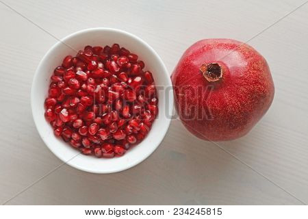 Grains Of Red Ripe Pomegranate Lie In A White Bowl. Big Ripe Red Granets Or Garnets. Fruits Of Red R