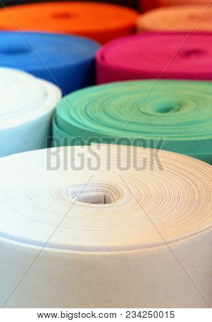 Selective focus view of colourfu rolls of felt