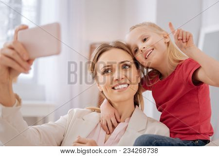 Our Photo. Happy Positive Nice Mother And Daughter Smiling And Looking Into The Camera While Taking 