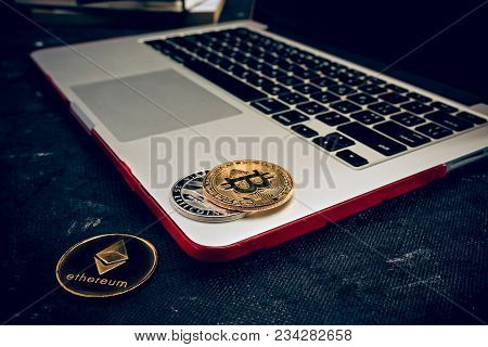 The Golden Bitcoin On Keyboard Of Notebook. Cryptocurrency Bitcoin Coins. Litecoin, Bitcoin, Ethereu