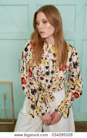 Girl With Long Hair, Long Sleeve Shirt With Floral Print And Wide White Pants. A Wistful Romantic Lo