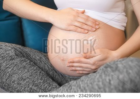 Closeup Pregnant Woman Applying Moisturizing Cream At Her Belly For Prevention Of Stretch Marks. Pre