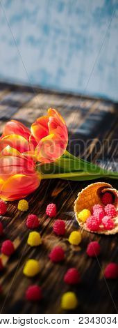 Blossoming Red Tulips On A Wooden Background With Sweets