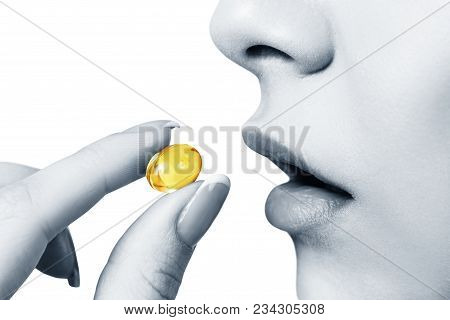 Close-up Shot Of Woman Brings The Pill To Her Mouth. Isolated On White Background.