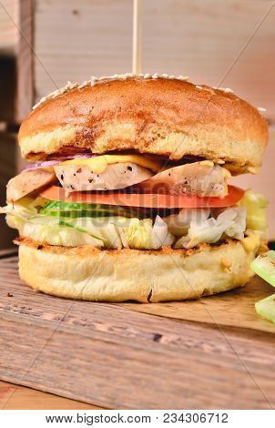 Top View Fresh Homemade Burger With Chicken, Salad, Cheese, Onion, Cucumber, Tomato, Sause And Dark 