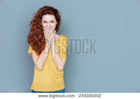 Pleasant Feelings. Joyful Nice Delighted Woman Covering Her Mouth And Looking At You While Expressin