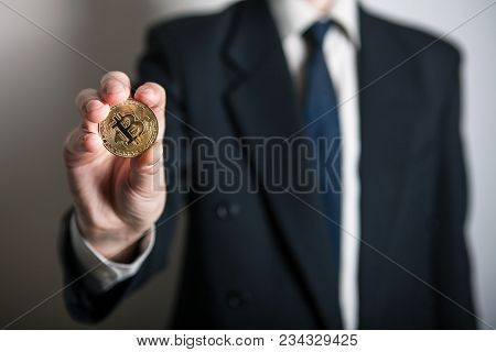Golden Bitcoin In A Man Hand, Digitall Symbol Of A New Virtual Currency. Man Recived Money From Bitc