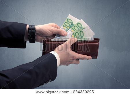 Businessman's hand in suit takes out eruo from his wallet