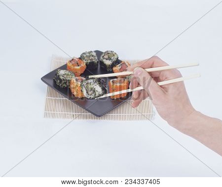 Different Types Of Maki Sushi On A Black Plate.isolated On White Background
