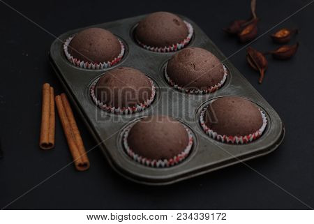 Just Baked Homebaked Chocolate Muffins For Dessert With Colored Conffeti. Black Background.